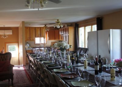 Kitchen/Dining seat 55+ guests. Image showing huge table with a lot of chairs and kitchen in background. - Pic 3 different angle